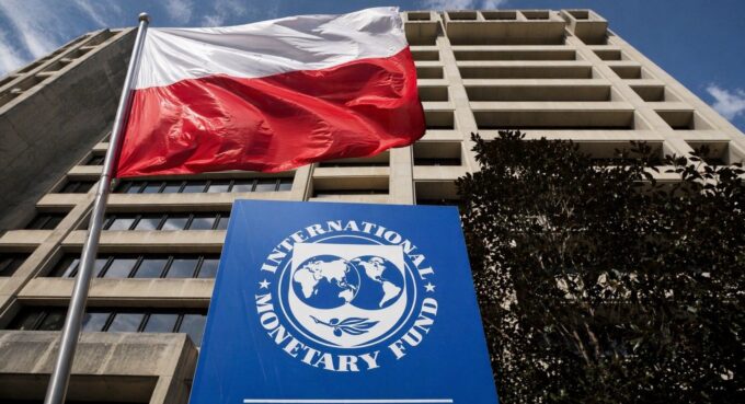 MFW Polska wzrost gospodarczy – polska flaga na tle siedziby Międzynarodowego Funduszu Walutowego, ilustracja do tekstu o prognozach wzrostu gospodarczego Polski i Europy.